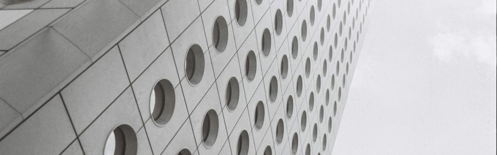 Low-angle view of iconic Hong Kong skyscraper in black-and-white, showcasing its modern design.