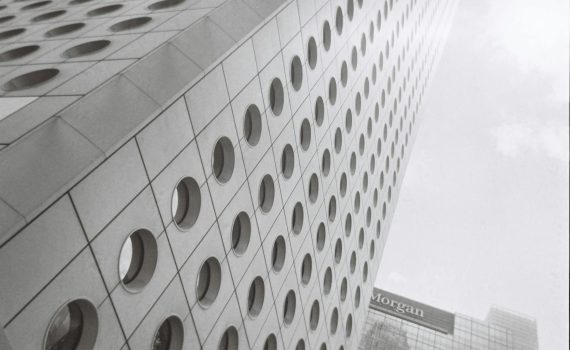 Low-angle view of iconic Hong Kong skyscraper in black-and-white, showcasing its modern design.