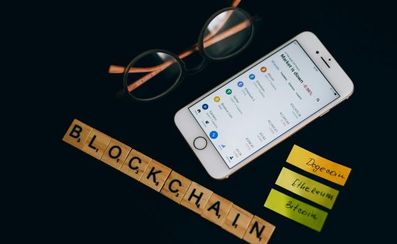 Smartphone displaying cryptocurrency market data alongside blockchain concept elements.