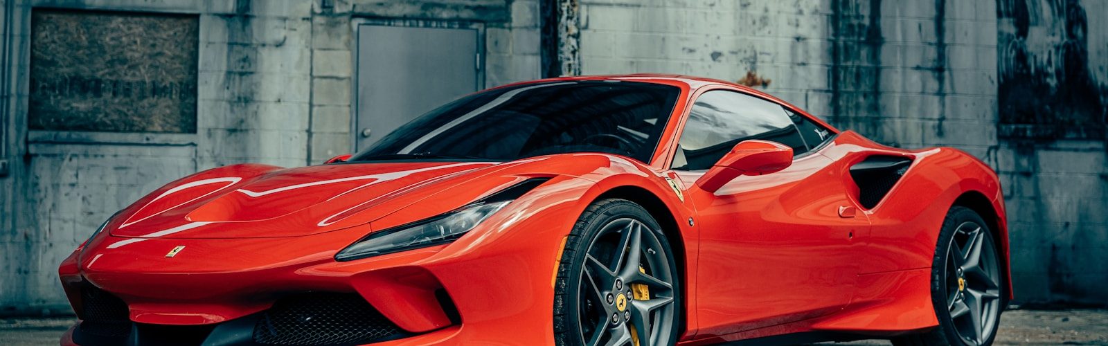 red ferrari 458 italia parked near gray building