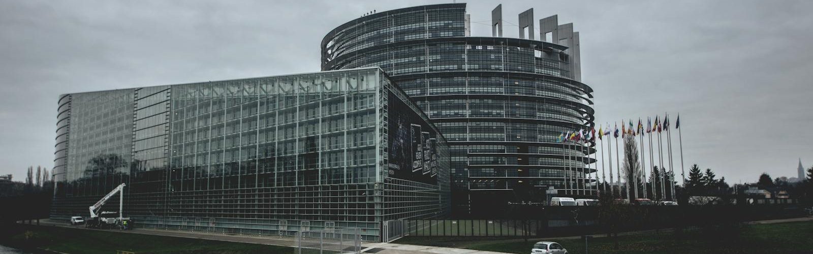 Modern architecture of the European Parliament in Strasbourg on a cloudy day.