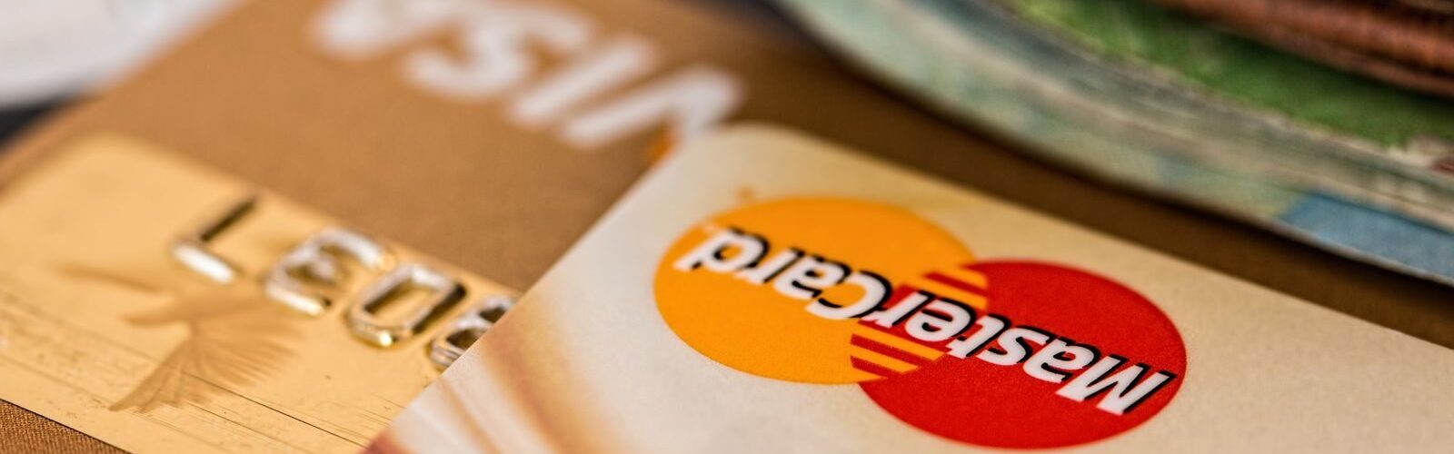 Macro shot of credit cards showing Visa and Mastercard logos next to a wallet, ideal for finance themes.