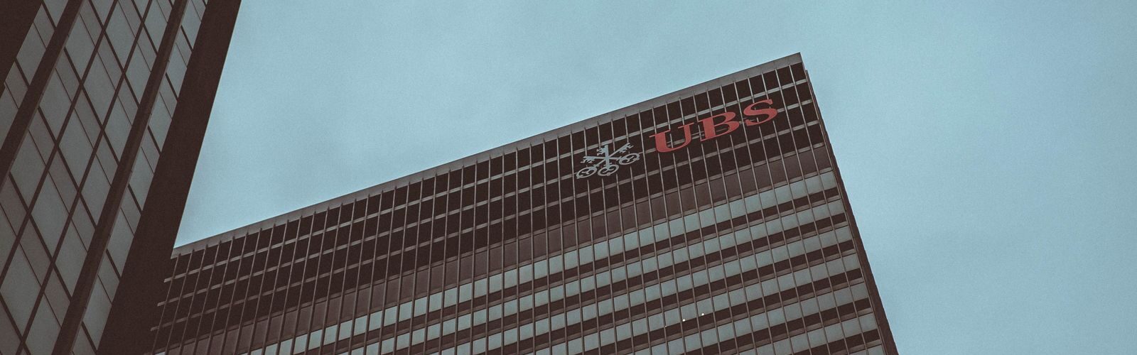 Modern skyscraper featuring the UBS logo against a clear sky in New York City.