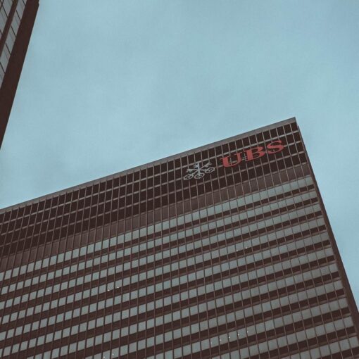 Modern skyscraper featuring the UBS logo against a clear sky in New York City.