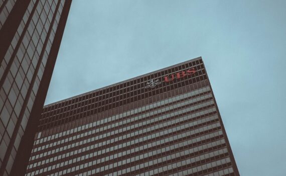 Modern skyscraper featuring the UBS logo against a clear sky in New York City.